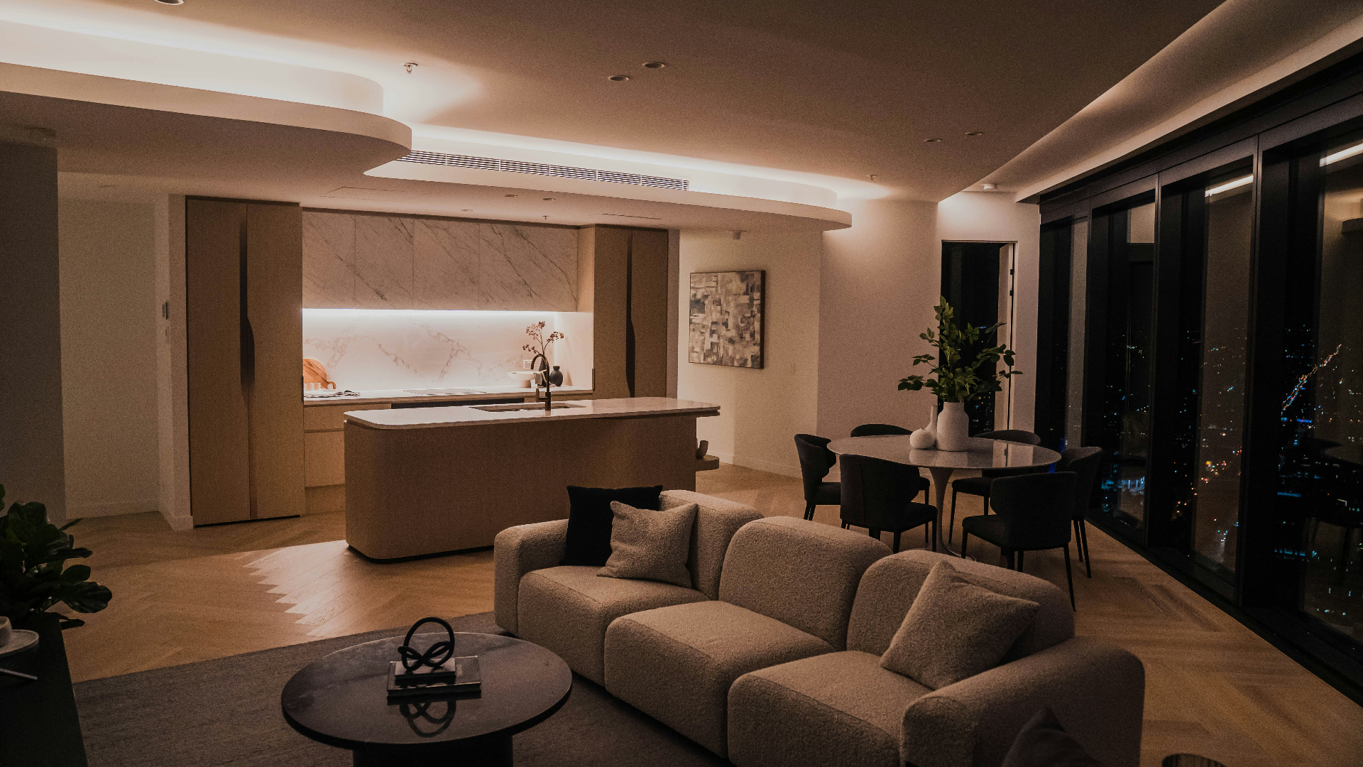 Modern kitchen and living room finished in Spencer Tiles surfaces at night